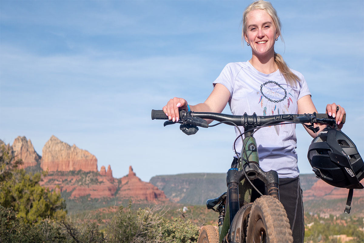 Moxie Tee Jersey Lilac Dreamcatcher worn by cyclist, featuring quick-dry fabric and two back pockets.